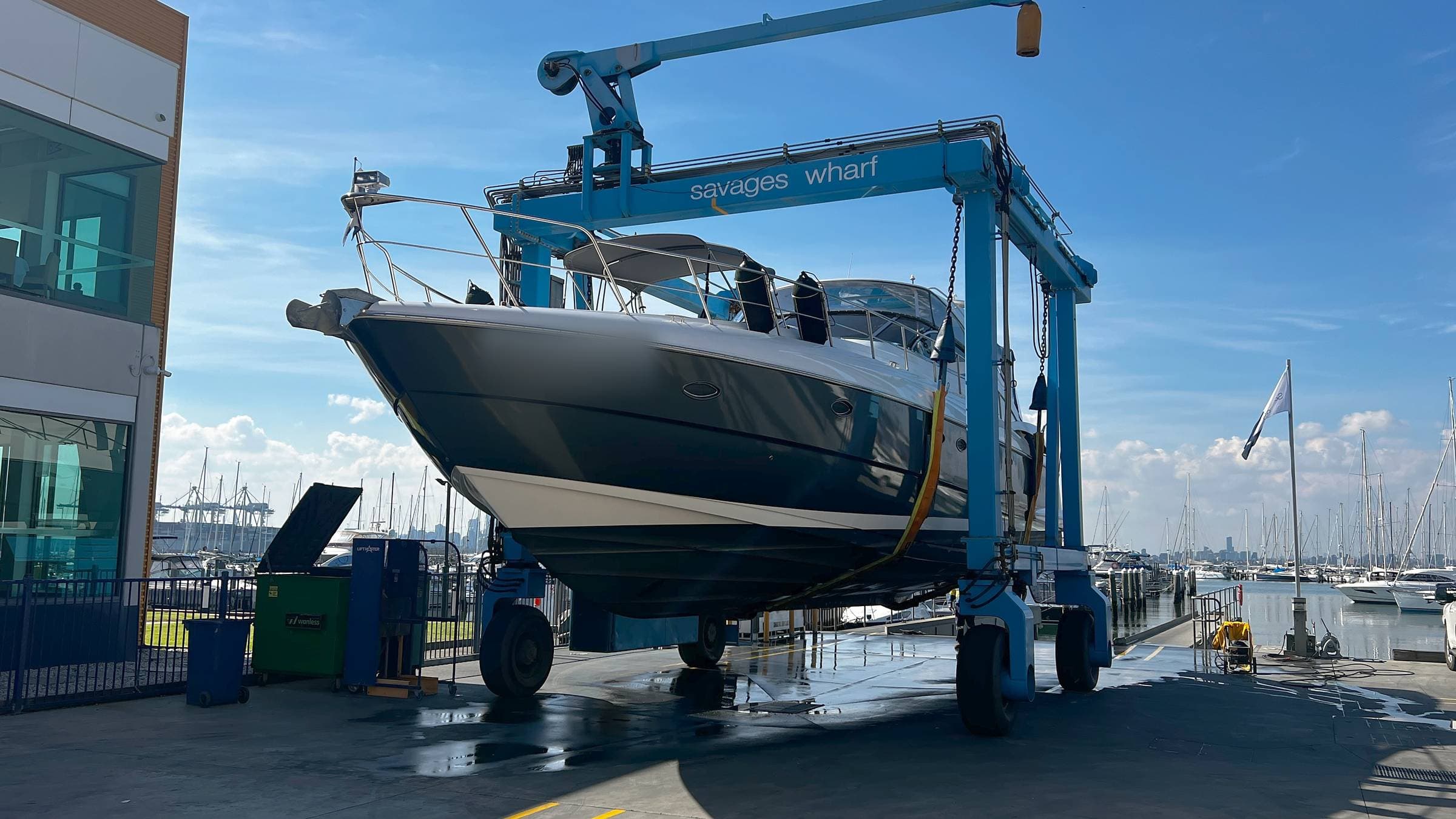 A motor cruiser in the travel lift at Savage’s Wharf, Williamstown, for service by Mariner Engineering